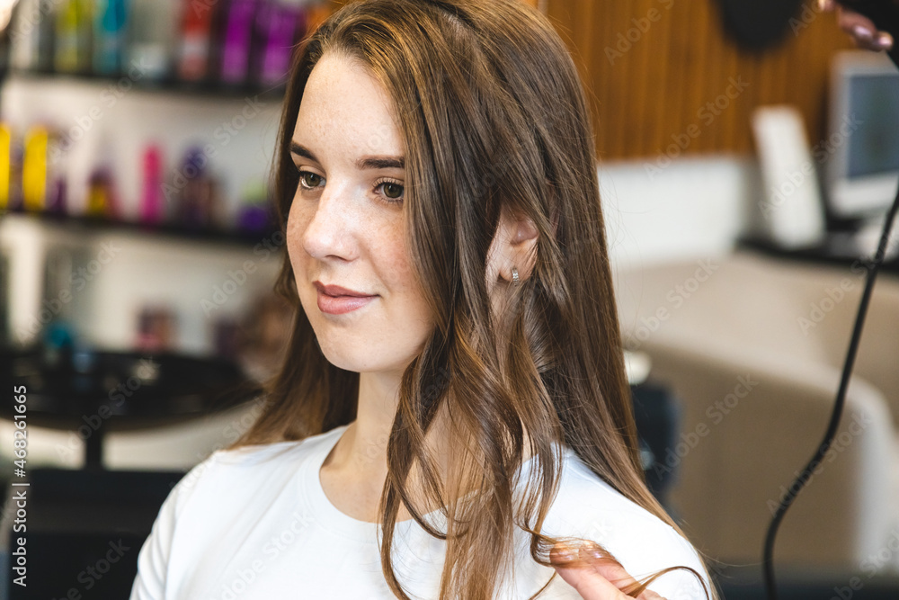 Canvas Prints Master woman hairdresser gently curls hair curling girl in a beauty salon. Hair styling