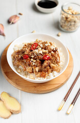 chinese dish. Kung pao, rice with chicken fillet in sauce. Close-up on a light background, vertical
