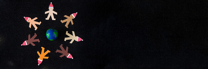 Banner of human multicultural paper puppets at Christmas time wearing Santa's hats and being united...