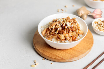 chinese food. Kung pao, rice with chicken fillet in sauce. Close-up on a light background, horizontal