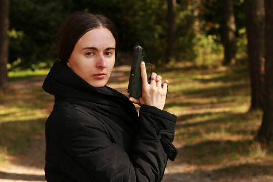 Brunette woman with a pistol in the forest