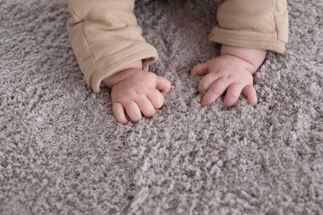  hands of baby crawling on floor or carpet