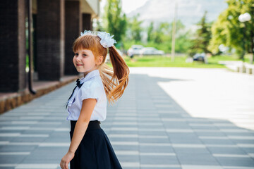 A little girl, an elementary school student, is spinning or dancing in the street. Back to school.