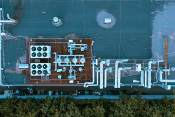 Industrial ventilation system of cooling, cleaning and air conditioning on the roof of the supermarket. Aerial top view shot. Metal pipes and coolers with fans on the roof of the supermarket.