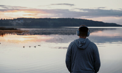 A man listens to harmonious music for peace of mind. Balance and harmony in nature privacy.