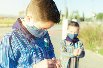 Kids with face mask for Covid protection openning a firecrackers box