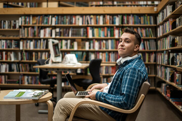 College break. Wireless headphones listening to an audiobook.  Male online education via the...
