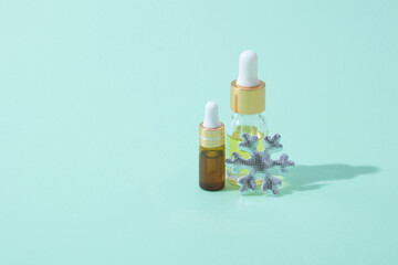 Cosmetic bottles of oil and serum with pipette with winter decor