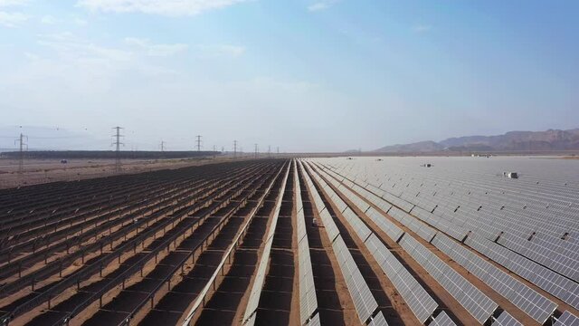 Aerial View of Solar Panel Park or farm Solar panels in the desert among the mountains. Drone Aerial Shot Of Power Station Over Landscape On Sunny Day Against Sky at the Negev, Israel.