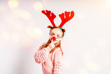 Cristmas concept. Little girl having fun wearing Christmas party glasses with reindeer antlers and...