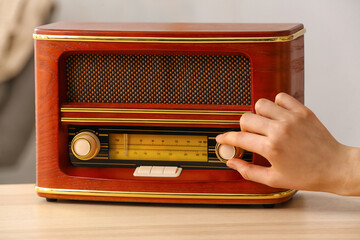 Woman switching on the radio at home