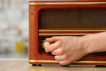 Woman switching on the radio at home