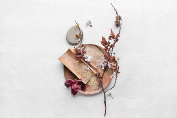 Plate with blossoming branch, sea salt and spa stone on white background
