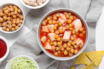 Bowl with delicious pozole soup and ingredients on light6 table