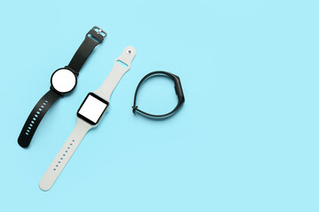 Different smart watches on color background