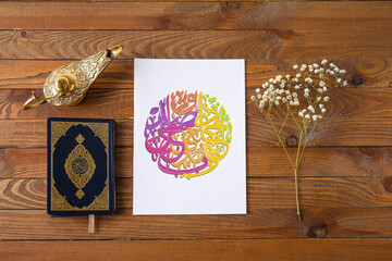Paper with Arabic text, lamp and Koran on wooden background