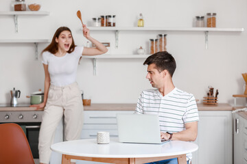 Fototapeta premium Young woman shouting at her boyfriend in kitchen