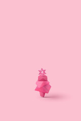 Christmas tree made of geometrical objects on pastel pink background. New year and Christmas idea. Minimal abstract winter holidays concept. With copy space.