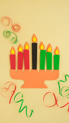 Happy Kwanzaa Greeting Card Background. Candleholder made from paper leaves. Paper art concept. Vertical banner mockup