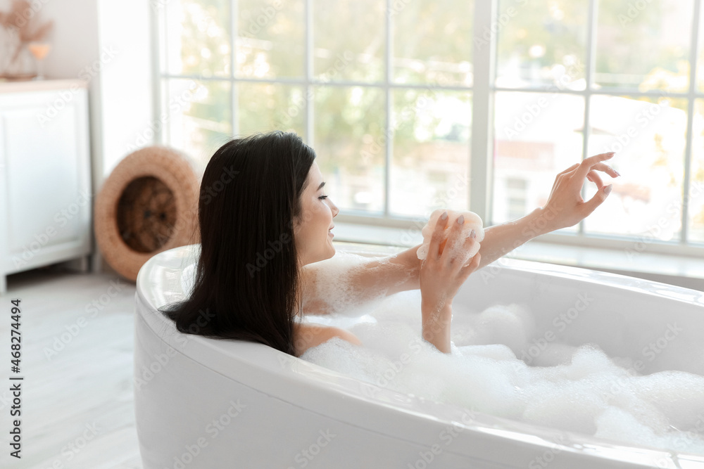 Sticker relaxed young woman taking bath with loofah at home