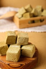 Board with tasty hojicha marshmallows on color background, closeup