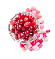Cranberry pills and bowl of berries on white background