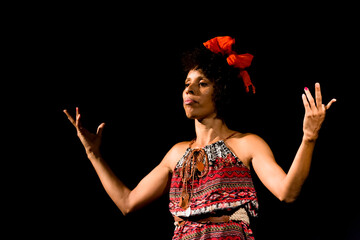 Actress on stage represents a dramatic character. She is standing.