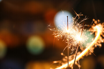 Beautiful burning sparklers at night city, closeup
