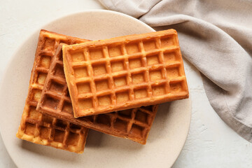 Plate with delicious golden Belgian waffles on white background