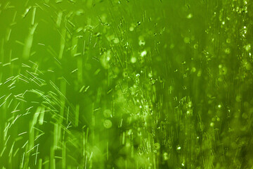 Green coloured shower water droplets going up then coming down from a shower head - stock photo