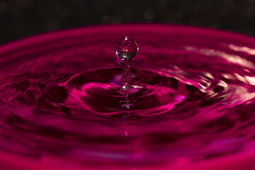Pink water splash orb balanced on a water spike - stock photo