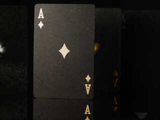 Casino, online casino. Black poker cards with gold lettering on a black background. Stylish composition. There are no people in the photo. Gambling, poker, game strategy.