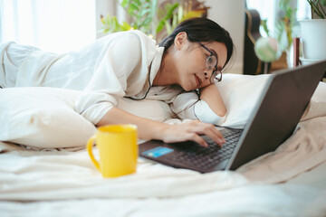 young Asian woman freelance working business work on laptop at home, working from home concept