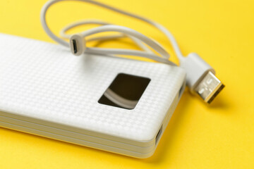 Modern power bank on yellow background, closeup