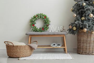Beautiful mistletoe wreath with Christmas tree bench in interior of room