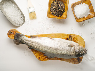 Fish prepared for salting and pickling. Salt, spices and fish on a cutting board. White background....