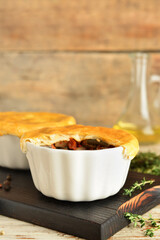 Tasty vegetable pot pies on wooden background