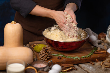 The chef prepares the dough for the American pumpkin pie. Ingredients, decor. Rough wood texture. Country style. Halloween, Thanksgiving, Harvest Festival, Christmas, New Year.