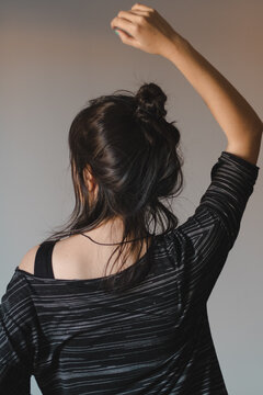 Mulher de costas sem rosto pose delicada fundo claro simples e minimalista