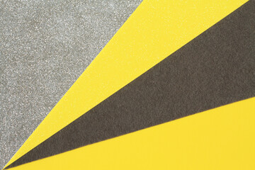 Fototapeta premium Gray and yellow foamiran sheets folded on a white sheet of Whatman paper. Closeup. View from above