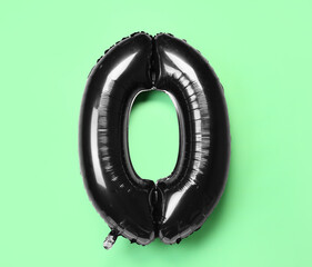 Black balloon in shape of figure 0 on green background