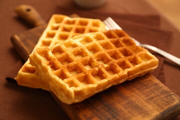 Wooden board of tasty Belgian Waffles on table in cafe