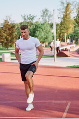 Obraz premium athletic men doing exercises on the sports ground in summer