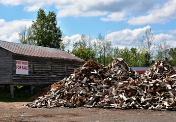 Large piles of split firewood for sale.