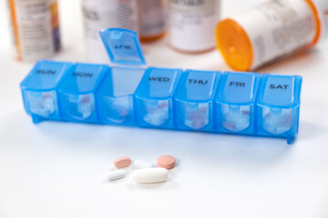 Blue color medicine organizer with prescription bottles isolated on white background