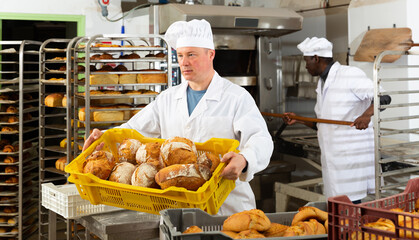 Portrait of baker with fresh bread at the bakery. High quality photo