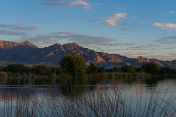 Sunset colors on mountains beyond a small lake in Arizona