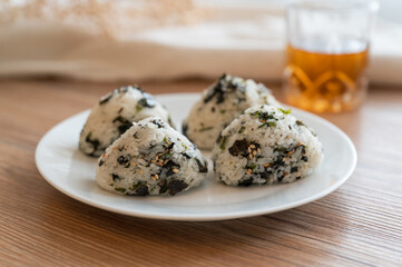There are four seaweed rice balls on the plate