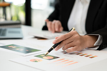 Businessman pen pointing turnover with graph chart report and use laptop computer for analysis data