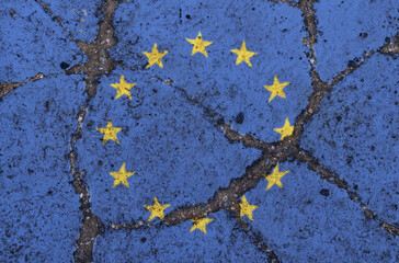 Obraz na płótnie Canvas UE flag on cracked asphalt. The concept of crisis, default, pandemic, conflict, terrorism. Out of focus image